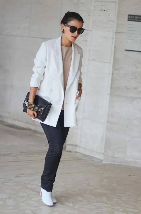 un top neutru, blugi negri drepti, cizme albe, un blazer supradimensionat alb si o geanta neagra