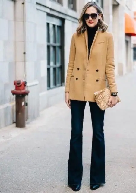 Cu ochelari de soare, turtleneck negru, clutch imprimat si cizme negre din piele